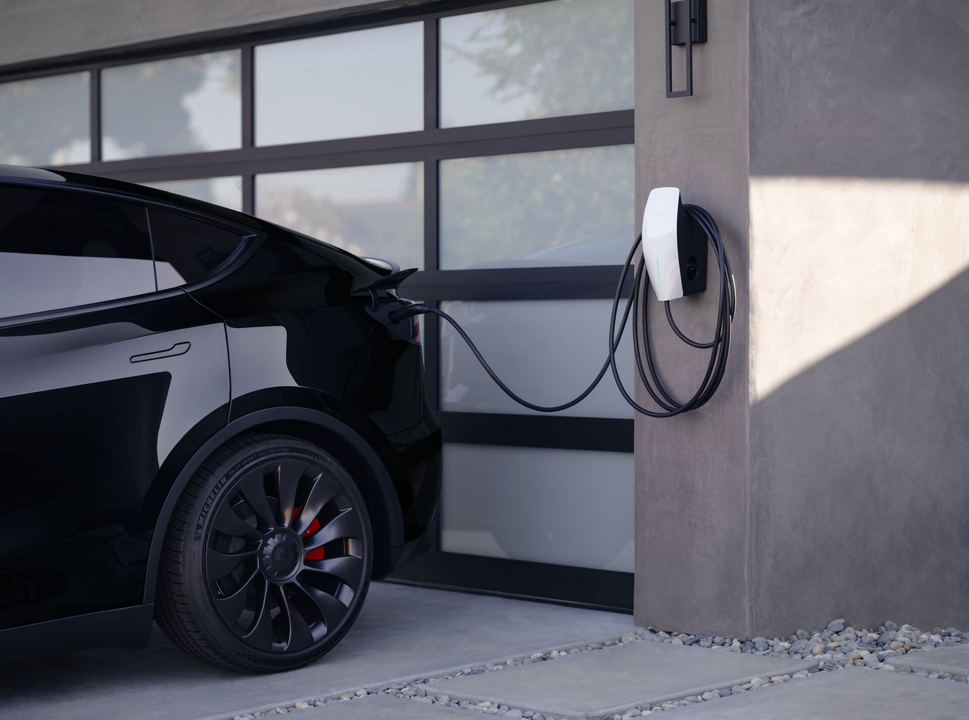 Tesla Wall Connector charging a car outside the garage.